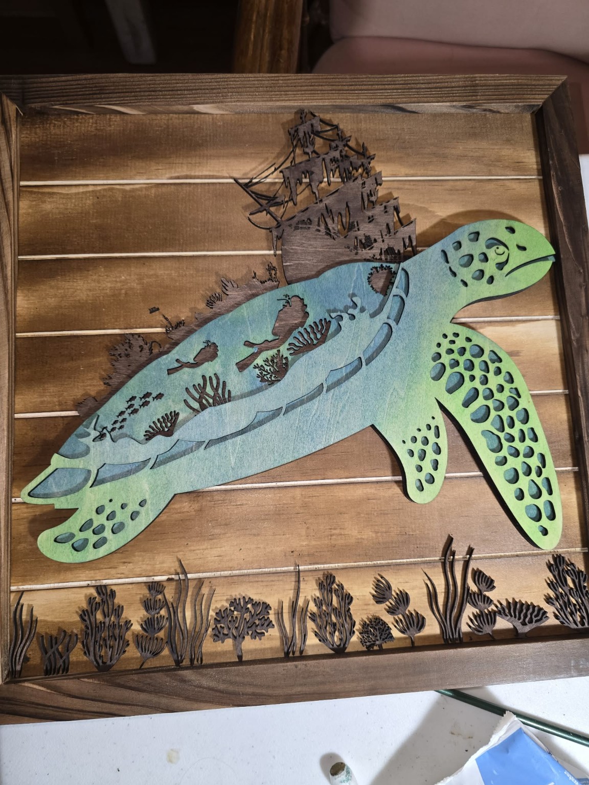 Fish and mountain scene engraved on wood