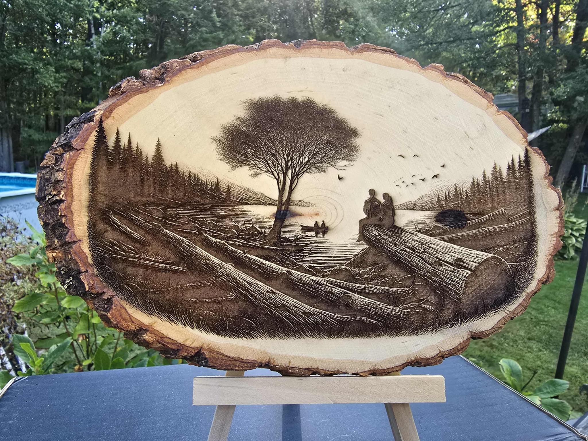 Wooden round plaque showing a fishing scene at sunset